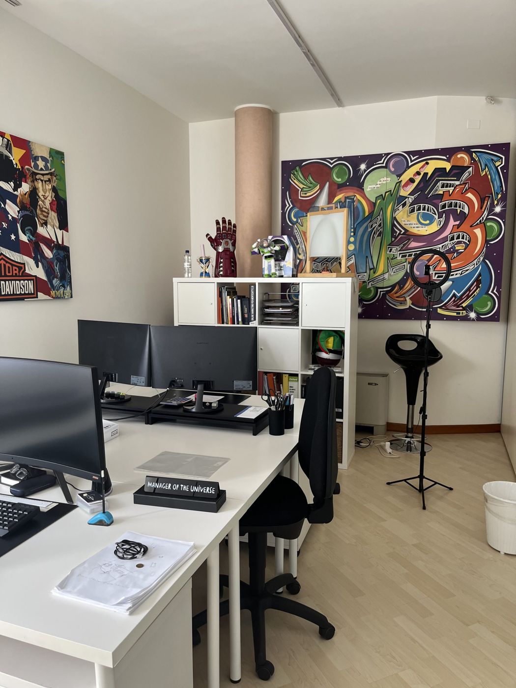 Ufficio con scrivanie, librerie e murale colorato